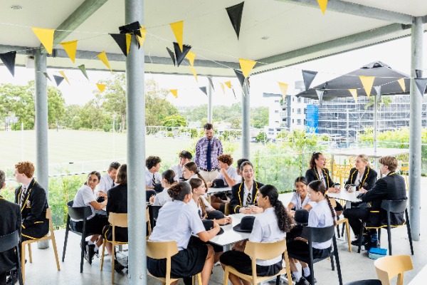 students socialising and collaborating outdoors in a shaded breakout area, reflecting student wellbeing, connection and a vibrant school community