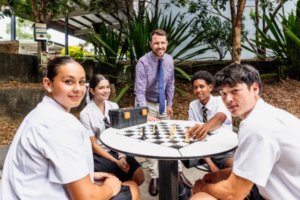 students and teacher playing chess