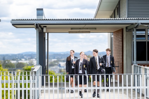 students walking together along an upper walkway on campus, representing student life, connection and a supportive school community