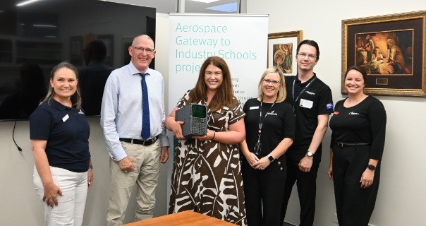 staff and industry representatives presenting a student project at an aerospace education showcase, reflecting partnership, innovation and real world learning opportunities