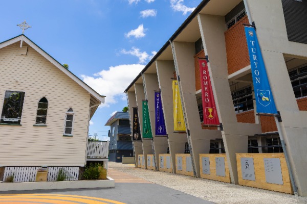 college building with house banners displayed along the walkway, representing school identity, tradition and community structure
