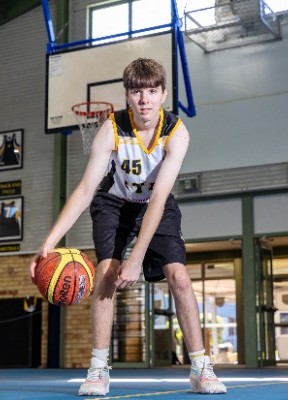 student dribbling a basketball on an indoor court, reflecting skill development, practice and school sport participation