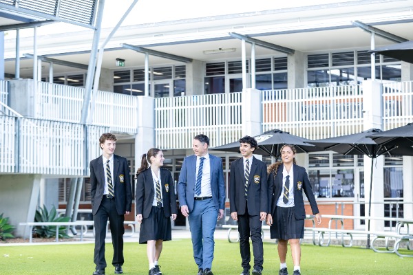 students and staff member walking together across the college grounds, representing leadership, connection and a supportive school community