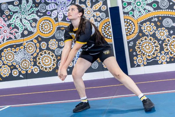 student preparing to receive a volleyball with a forearm pass, representing technique, focus and active participation