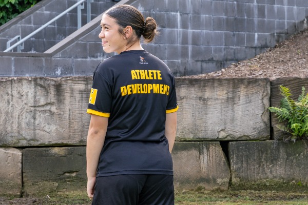 student wearing athlete development uniform viewed from behind, highlighting performance pathways, training focus and sporting culture