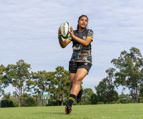 student preparing to pass a rugby ball while moving across the field, highlighting coordination, decision making and teamwork