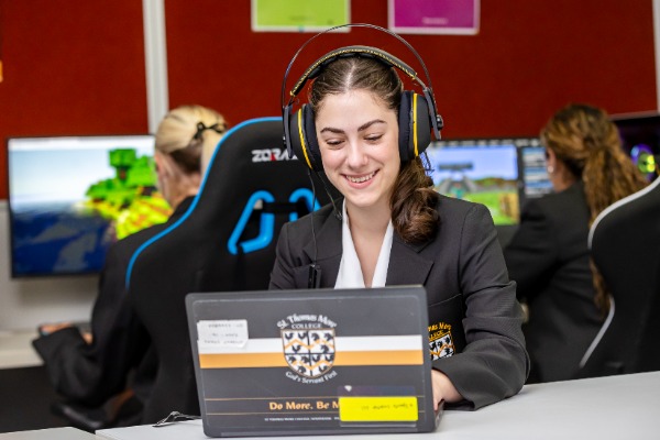 student using a laptop with headphones in a classroom setting, highlighting digital learning, focus and technology use
