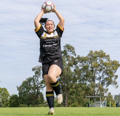 student performing a soccer throw in during a game, representing engagement, teamwork and school sport participation