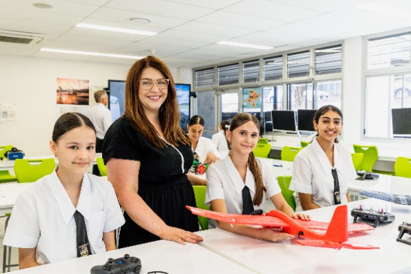 students and teacher collaborating on a hands-on STEM project with a model aircraft, reflecting innovation, practical learning and teamwork