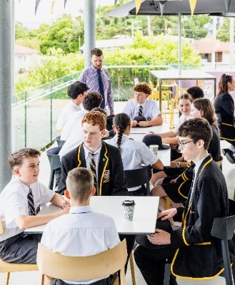 students and teacher engaged in group discussion in a shared learning space, reflecting community, engagement and active learning