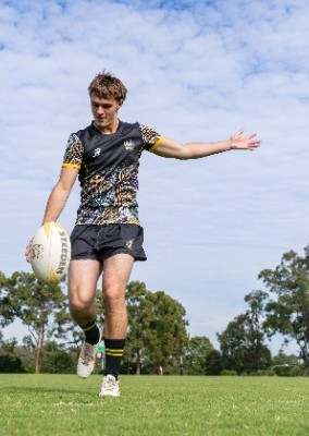 student kicking a rugby ball during play, reflecting skill development, technique and engagement in sport