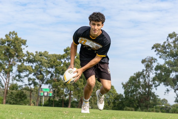 student running with a rugby ball across the field, reflecting speed, agility and engagement in school sport