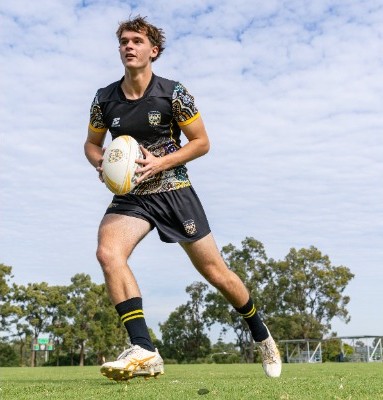 student running with a rugby ball across a sports field, representing speed, agility and active participation in school sport