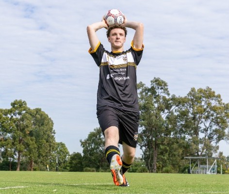student preparing to take a soccer throw in on a sports field, reflecting participation, skill development and teamwork in school sport