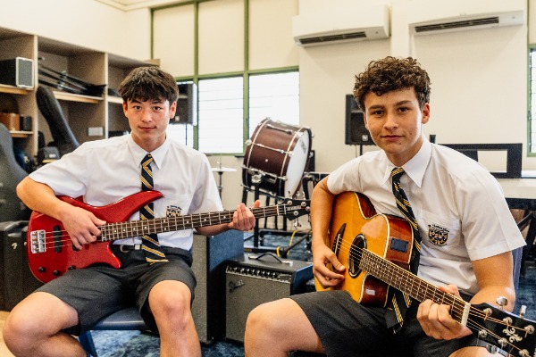 students playing guitar together in a music classroom, highlighting instrumental learning, creativity and participation in performing arts
