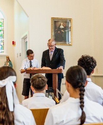 students participating in a liturgical reading with the principal, reflecting faith formation, leadership and shared worship