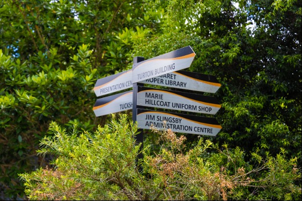directional signage on campus pointing to key facilities including library, administration and uniform shop, representing navigation, accessibility and school organisation