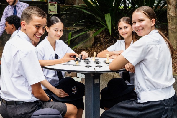 students playing a board game together in an outdoor break area, reflecting social connection, collaboration and student wellbeing